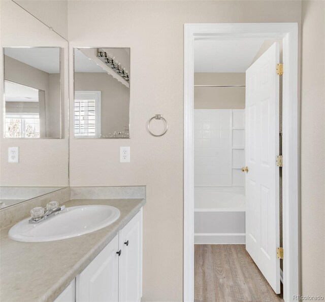 bathroom with vanity, shower / bathtub combination, and wood finished floors