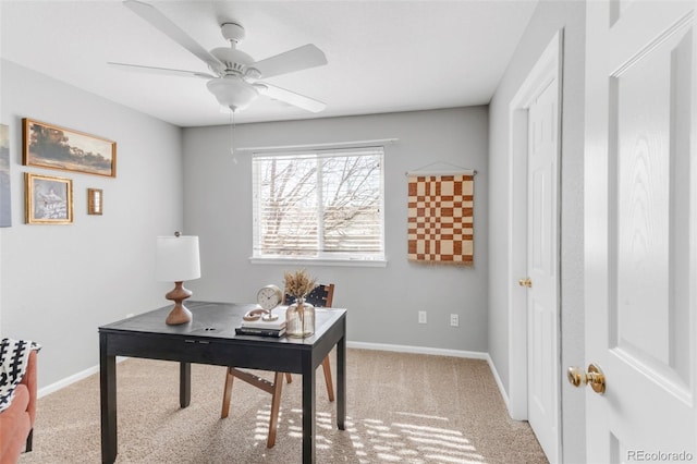 office space featuring light carpet, baseboards, and a ceiling fan