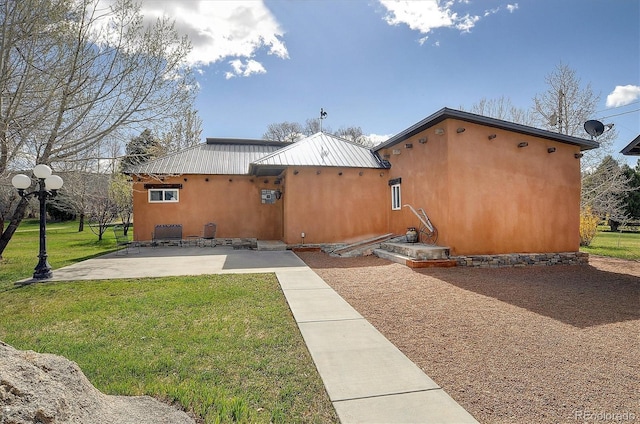 rear view of property featuring a patio and a yard