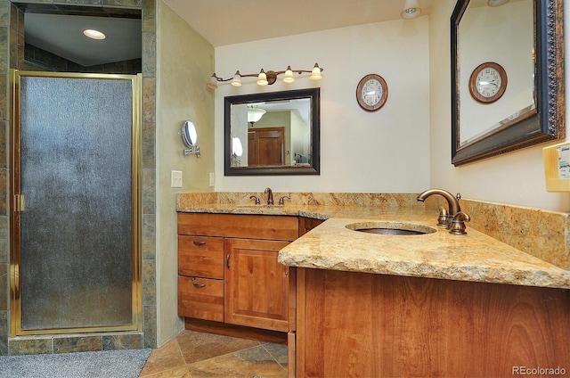 bathroom featuring a shower with shower door, tile flooring, and vanity