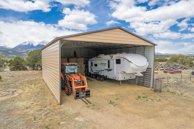 view of outdoor structure with a mountain view and a carport