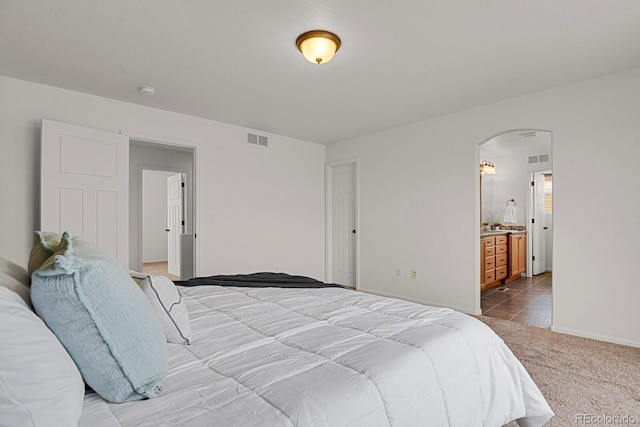 20826 Robins Dr, Denver, CO 80249 - carpeted bedroom with arched walkways, baseboards, and connected bathroom