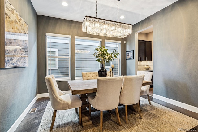 dining room featuring baseboards, visible vents, dark wood-style flooring, and a wealth of natural light