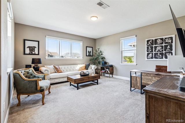 carpeted living room featuring visible vents and baseboards