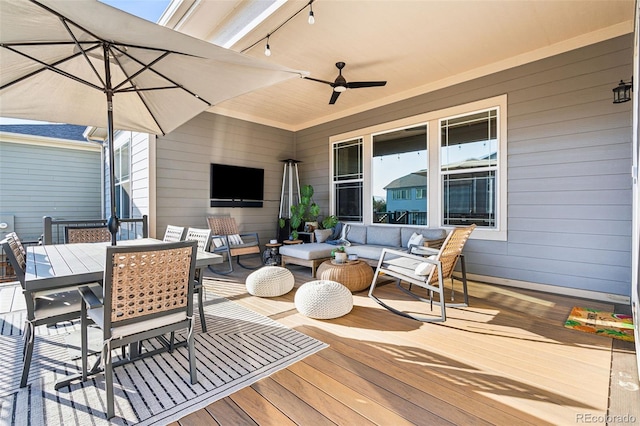 wooden terrace featuring a ceiling fan, outdoor dining area, and an outdoor hangout area