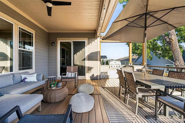 deck featuring outdoor dining area, outdoor lounge area, ceiling fan, and grilling area