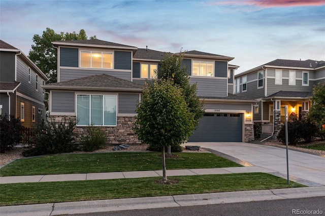 view of front of home with an attached garage, stone siding, concrete driveway, and a front yard