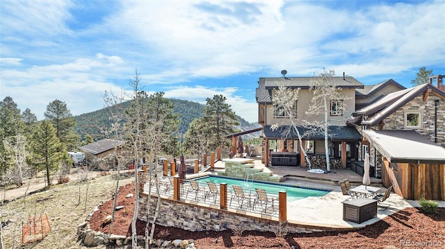 view of swimming pool featuring a patio area, a fenced in pool, a fenced backyard, a mountain view, and a jacuzzi