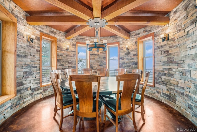 dining room featuring an inviting chandelier, wooden ceiling, concrete flooring, and beam ceiling