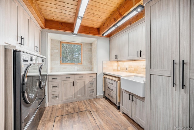 laundry area with cabinet space, a sink, separate washer and dryer, light wood-type flooring, and wood ceiling
