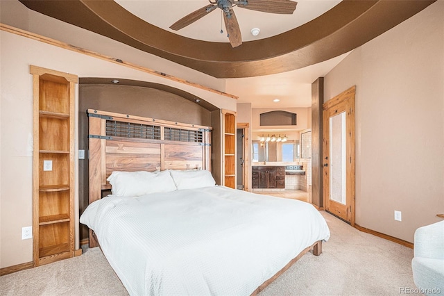 carpeted bedroom featuring baseboards, ensuite bathroom, and ceiling fan
