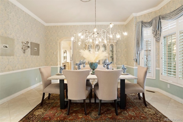 tiled dining room featuring ornamental molding and an inviting chandelier