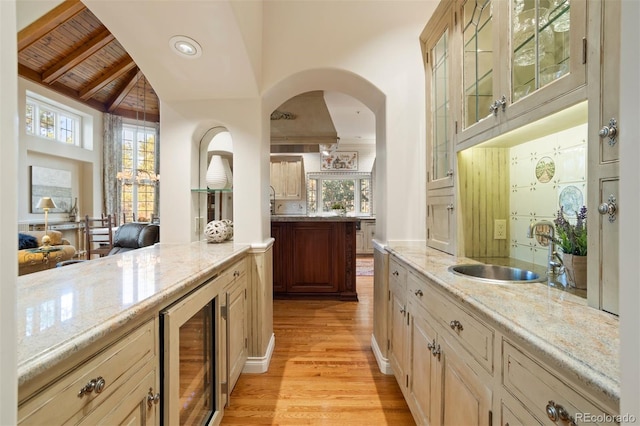 bar featuring sink, lofted ceiling with beams, light hardwood / wood-style floors, wooden ceiling, and wine cooler