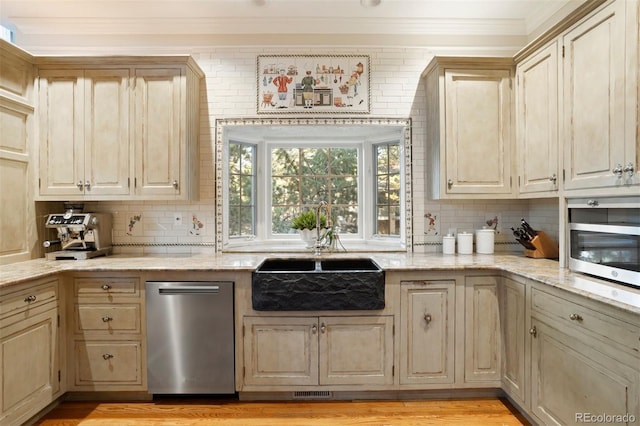 kitchen featuring appliances with stainless steel finishes, light wood-type flooring, and backsplash