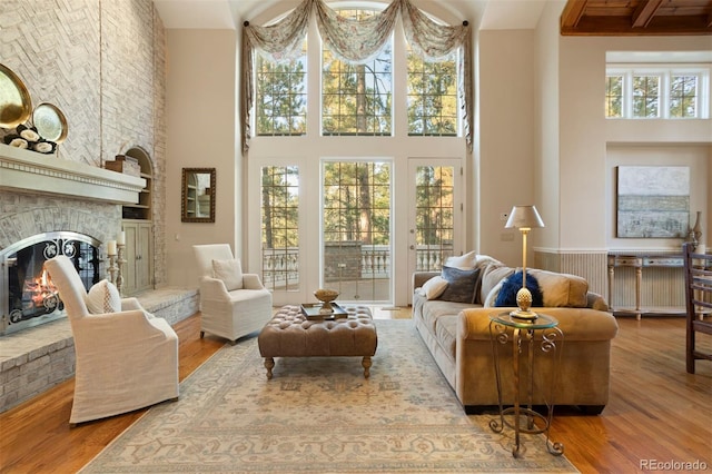 living area featuring hardwood / wood-style floors, a high ceiling, a fireplace, and a wealth of natural light