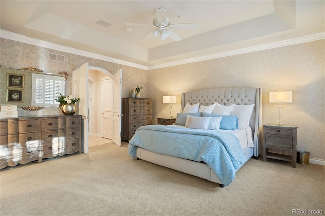 carpeted bedroom with a tray ceiling and ceiling fan