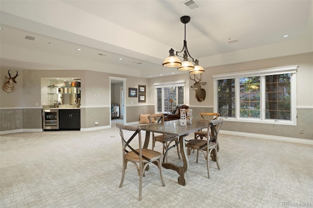 carpeted dining area with wine cooler and bar area