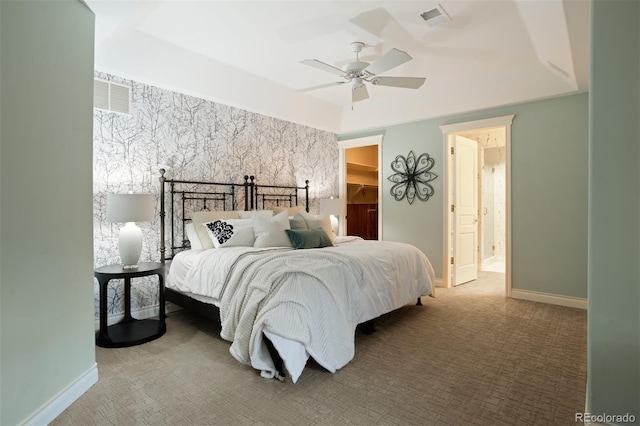 carpeted bedroom with connected bathroom, a walk in closet, and ceiling fan