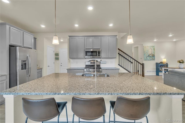 4884 St Vrain Rd, Firestone, CO 80504 - kitchen featuring appliances with stainless steel finishes, a sink, gray cabinets, light stone countertops, and recessed lighting