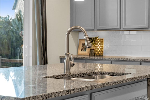 4884 St Vrain Rd, Firestone, CO 80504 - kitchen view of a sink, stone countertops, decorative backsplash, and gray cabinetry
