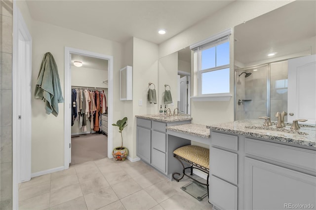 4884 St Vrain Rd, Firestone, CO 80504 - full bath featuring a shower stall, a walk in closet, vanity, baseboards, and tile patterned flooring