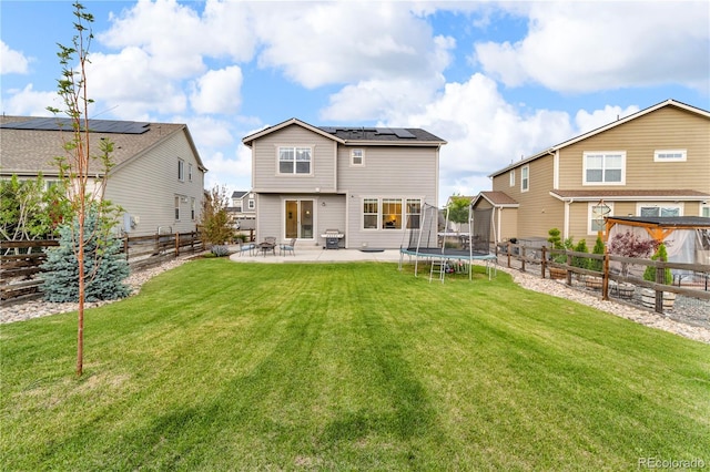 4884 St Vrain Rd, Firestone, CO 80504 - rear view of property featuring roof mounted solar panels, a patio, and a trampoline