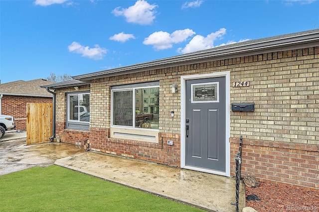 doorway to property featuring brick siding