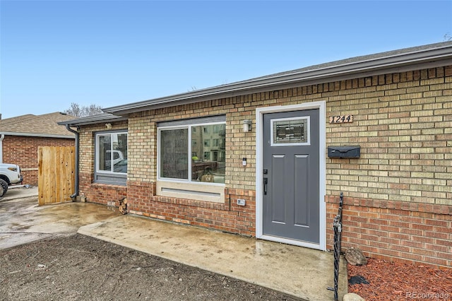 doorway to property with brick siding