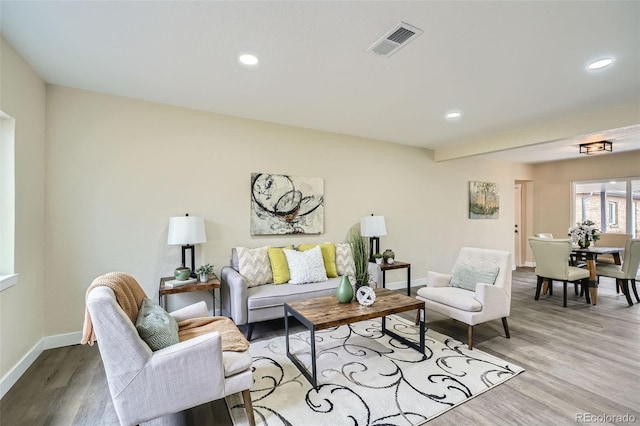 living room with recessed lighting, wood finished floors, visible vents, and baseboards