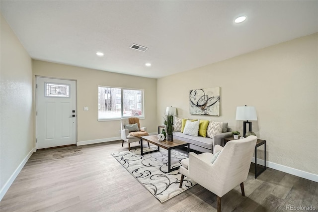 living area featuring wood finished floors, visible vents, and baseboards