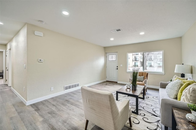 living room featuring light wood finished floors, visible vents, and recessed lighting