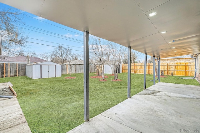 view of yard with a shed, an outdoor structure, a fenced backyard, and a patio