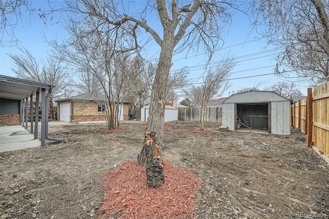 view of yard featuring a storage shed, a fenced backyard, and an outdoor structure