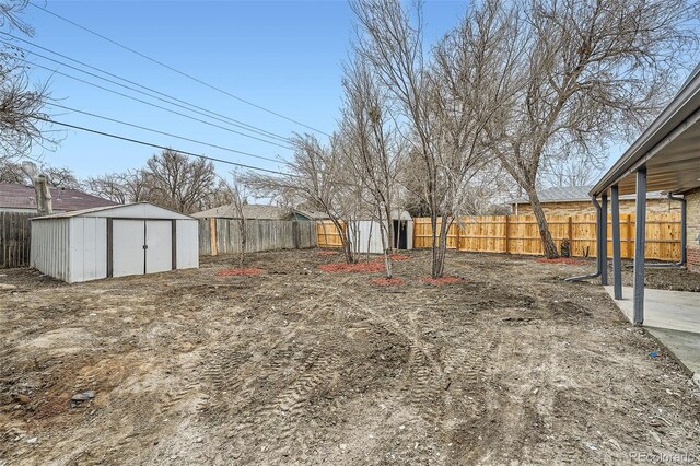 view of yard with an outbuilding, a fenced backyard, and a storage unit