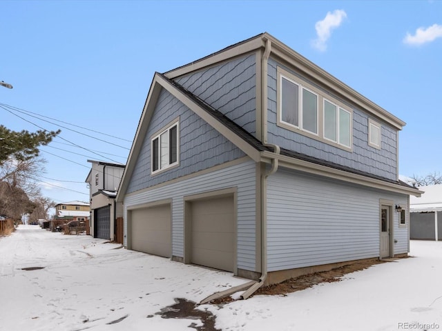 view of snowy exterior featuring a garage