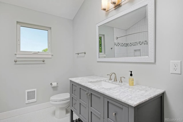 bathroom with vanity, toilet, tiled shower, and tile patterned flooring