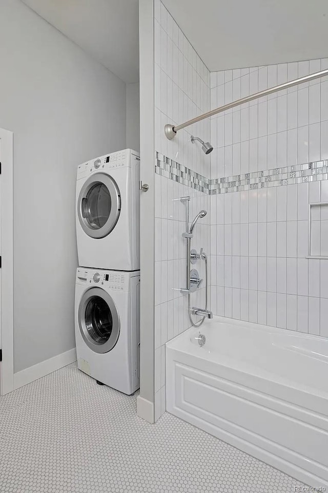 laundry room with light tile patterned floors and stacked washer / dryer