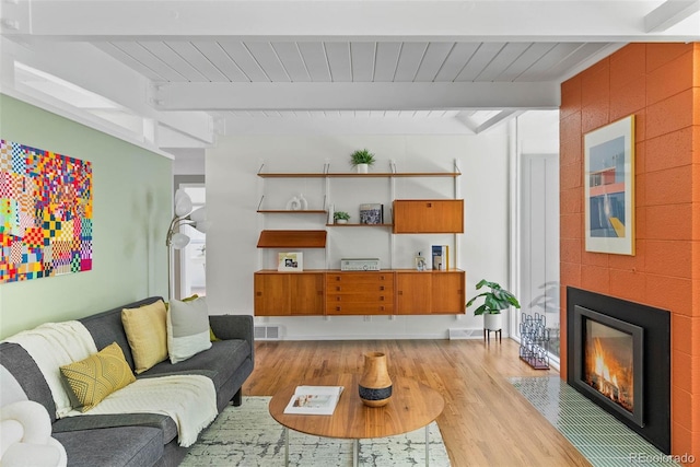 1338 S Fairfax St, Denver, CO 80222 - living room with beamed ceiling, light wood-style flooring, and a large fireplace