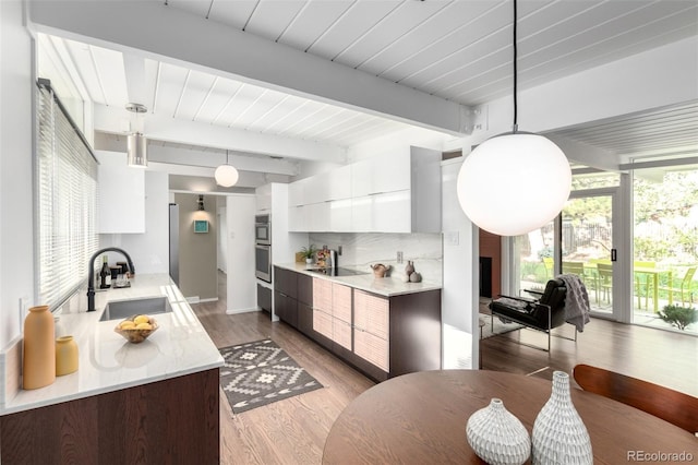 1338 S Fairfax St, Denver, CO 80222 - kitchen featuring modern cabinets, beamed ceiling, light countertops, white cabinets, and tasteful backsplash