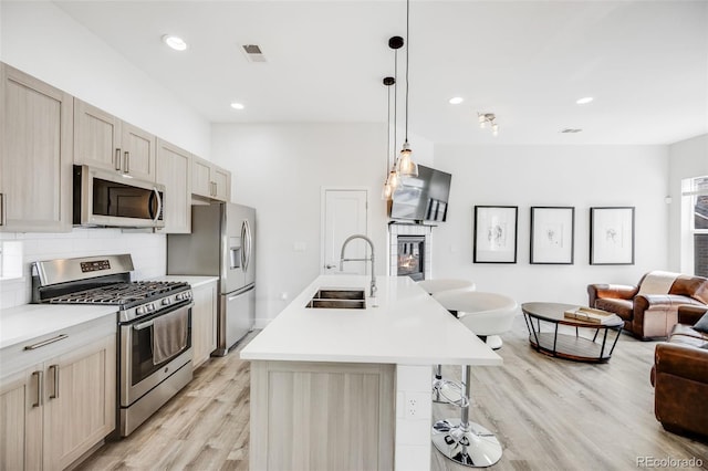 2922 W 26th Ave Unit 1, Denver, CO 80211 - kitchen with appliances with stainless steel finishes, open floor plan, light wood finished floors, decorative backsplash, and light countertops