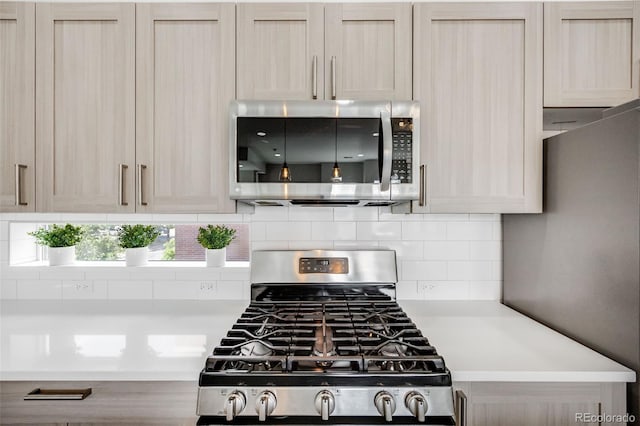2922 W 26th Ave Unit 1, Denver, CO 80211 - kitchen featuring appliances with stainless steel finishes, light countertops, and tasteful backsplash