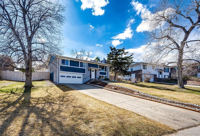 view of front of house featuring fence, driveway, a chimney, a front lawn, and a garage