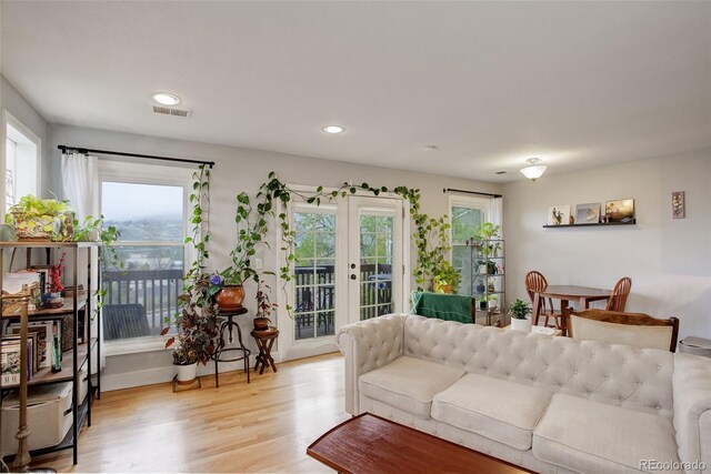 living area featuring french doors, light wood-type flooring, and recessed lighting