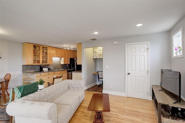 living room with recessed lighting, light wood-style flooring, and baseboards