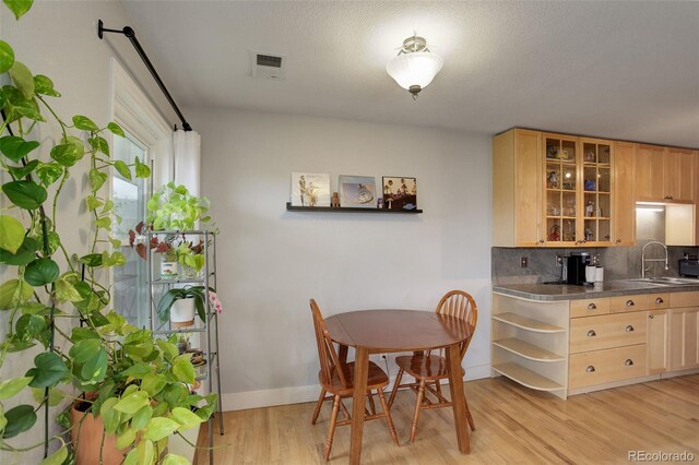 dining space featuring light wood finished floors and baseboards