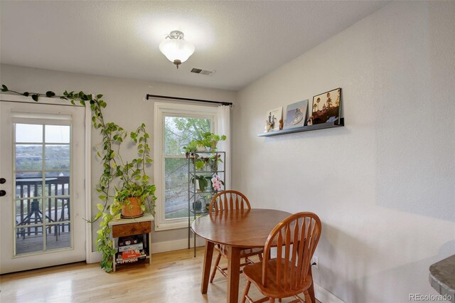 dining room featuring plenty of natural light, wood finished floors, and baseboards