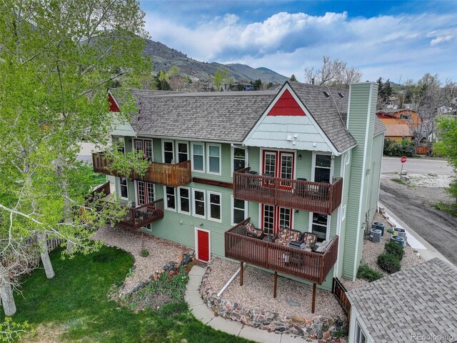 back of property featuring a balcony, a shingled roof, central air condition unit, and french doors