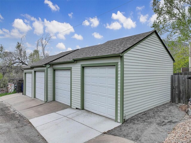 detached garage featuring fence