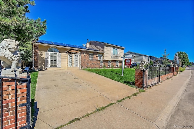 view of front of home featuring a front lawn and solar panels