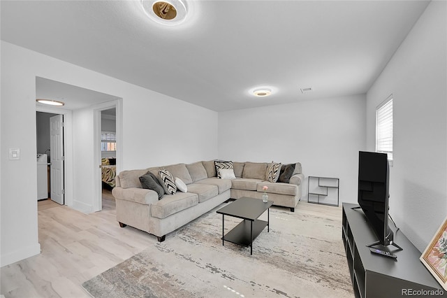 living room with light hardwood / wood-style flooring and washer / clothes dryer